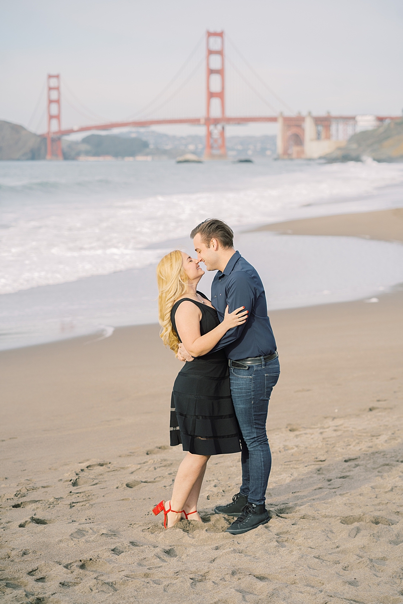 engagement photo on baker beach in san francisco with golden gate bridge