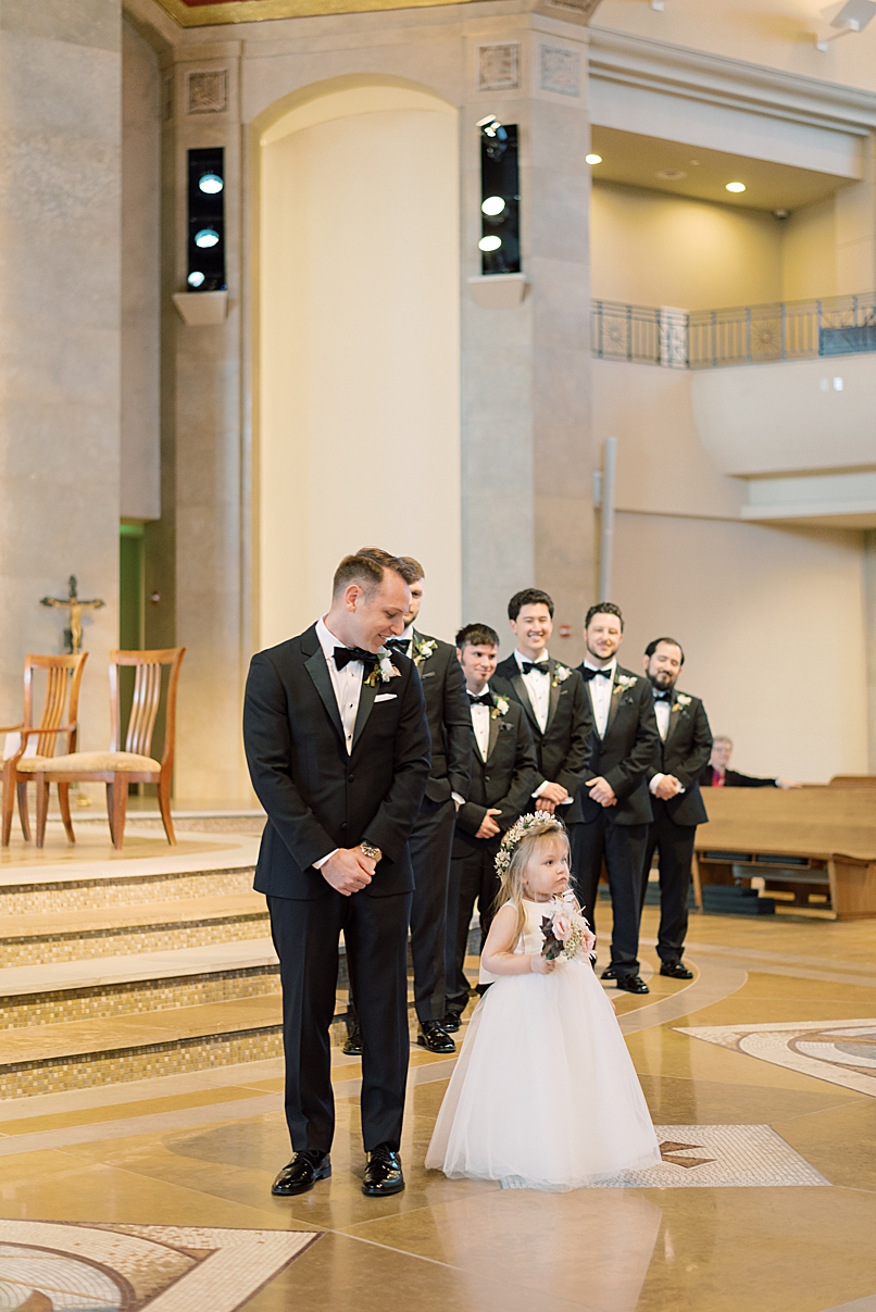 groom looking at flower girl