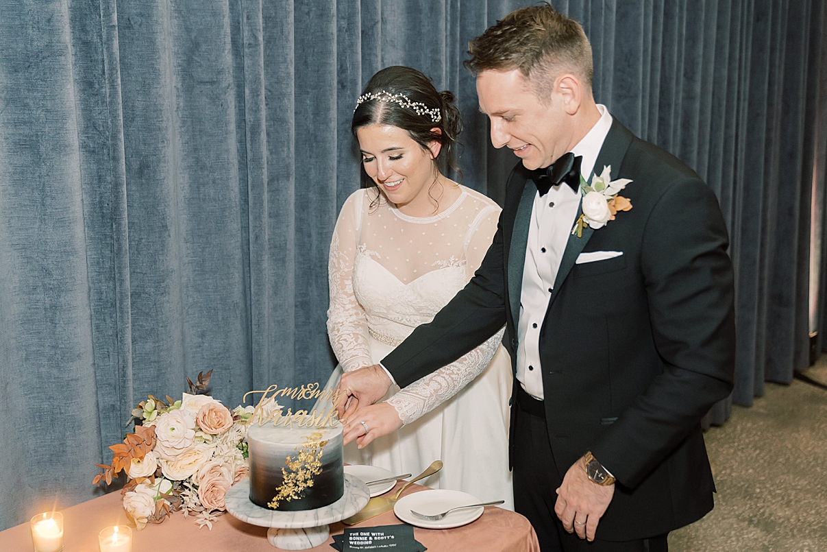 bride and groom cutting cake photo by paige vaughn