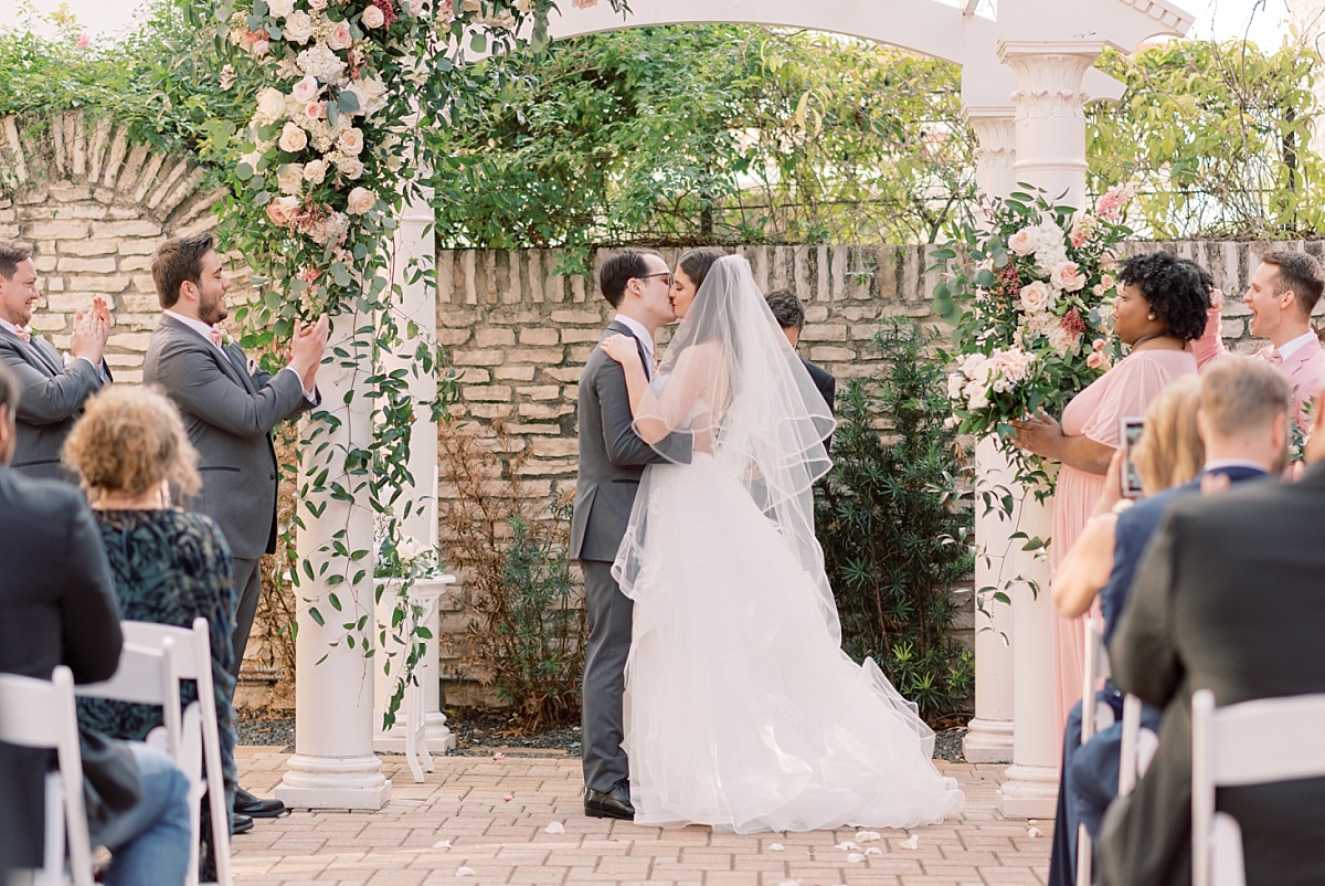 A Caucasian couple kisses at the alter after being wed at The Mansion in Austin, Texas, moment captured by Austin wedding photographer Paige Vaughn.