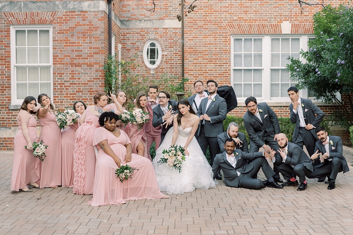 A fun wedding party strikes a sassy pose together while having wedding photographs taken in Austin, Texas by Paige Vaughn photography.