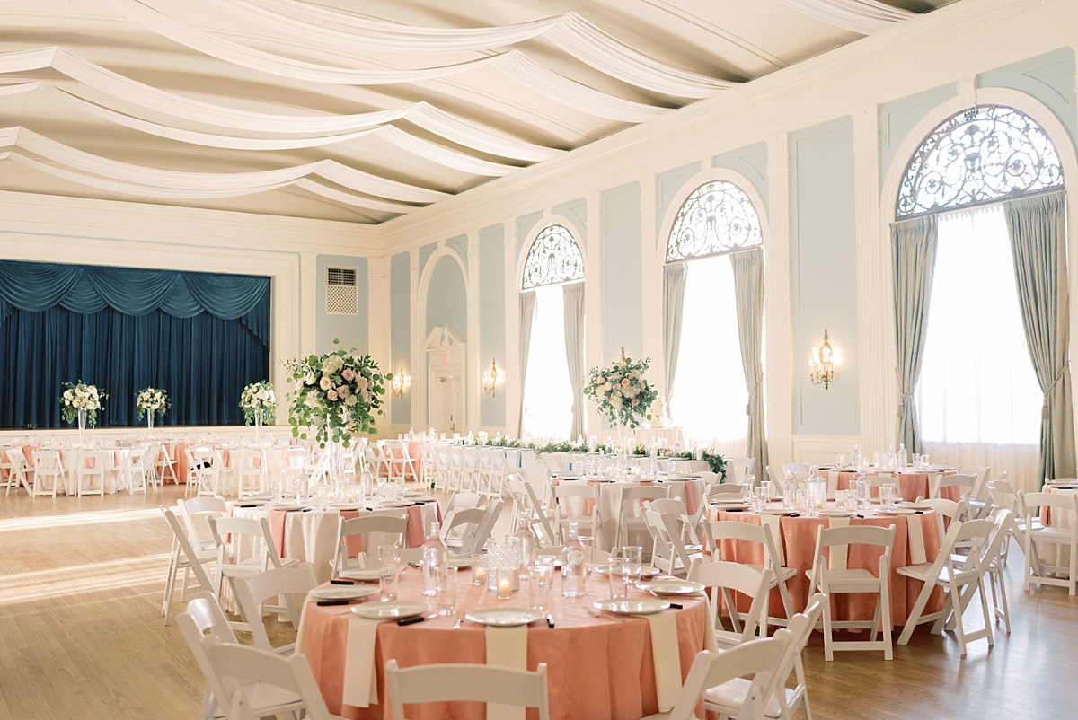The ballroom of The Mansion in Austin, Texas decorated for a wedding with pale blue walls and blush pink table settings.