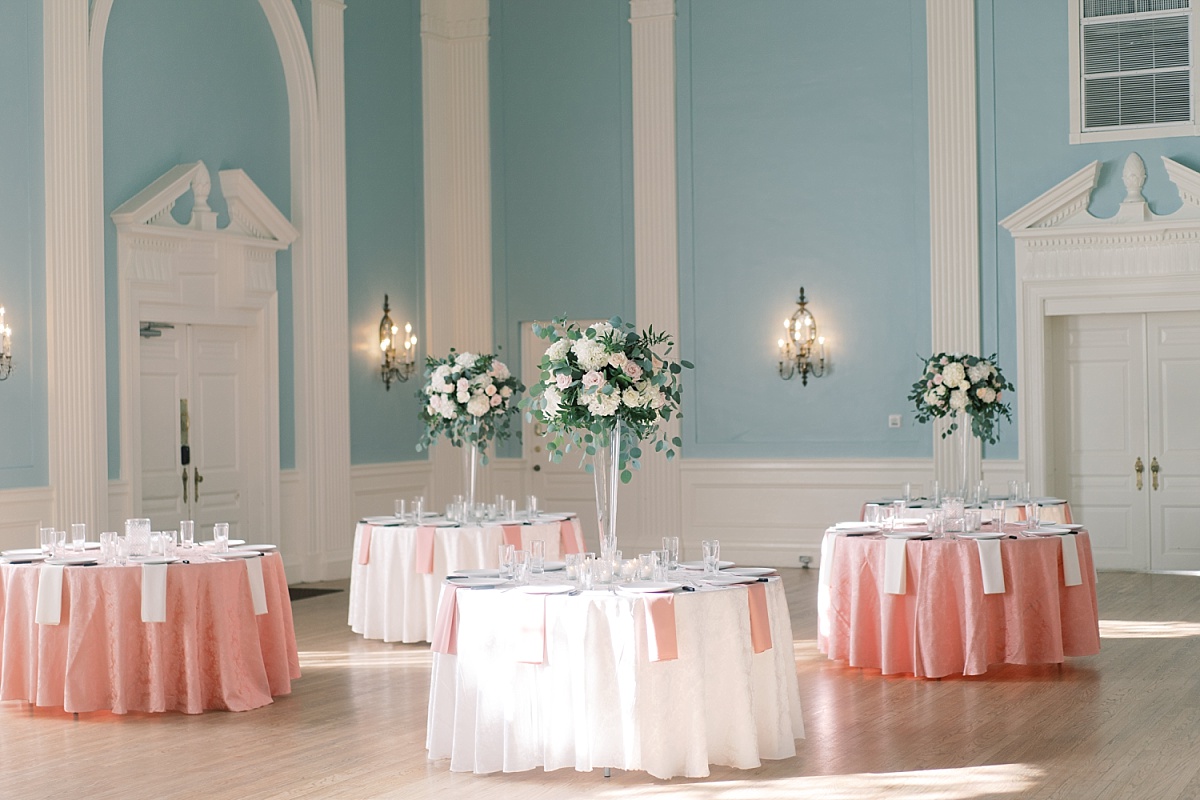 Elegant wedding table setting featuring blush pink and white flowers and table settings in the pale blue ballroom at The Mansion in Austin, Texas.