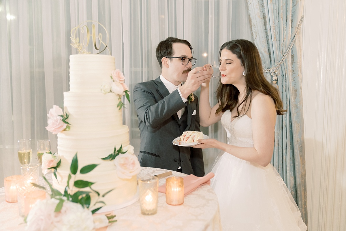 A Texas bride and groom take the first bite of a beautiful white cake by Sweet Treets Bakery