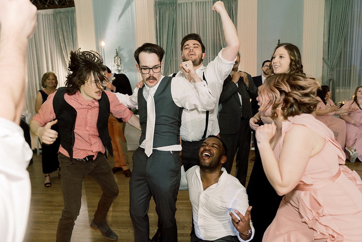 Groom dances with wedding party guests at reception in Austin, Texas.