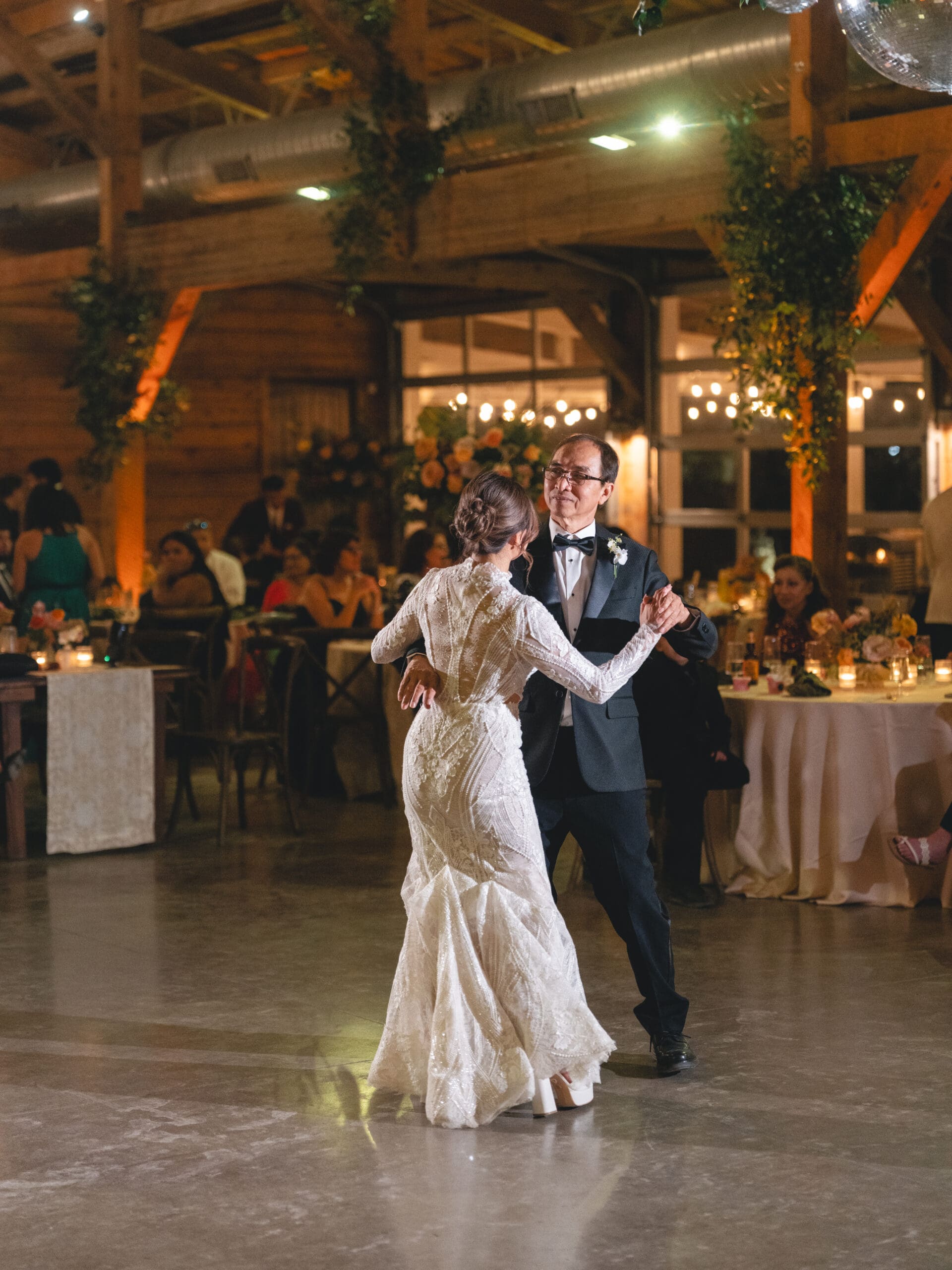 First dance moment of Oanh and Jeremy in the barn at The Addison Grove surrounded by friends and family
