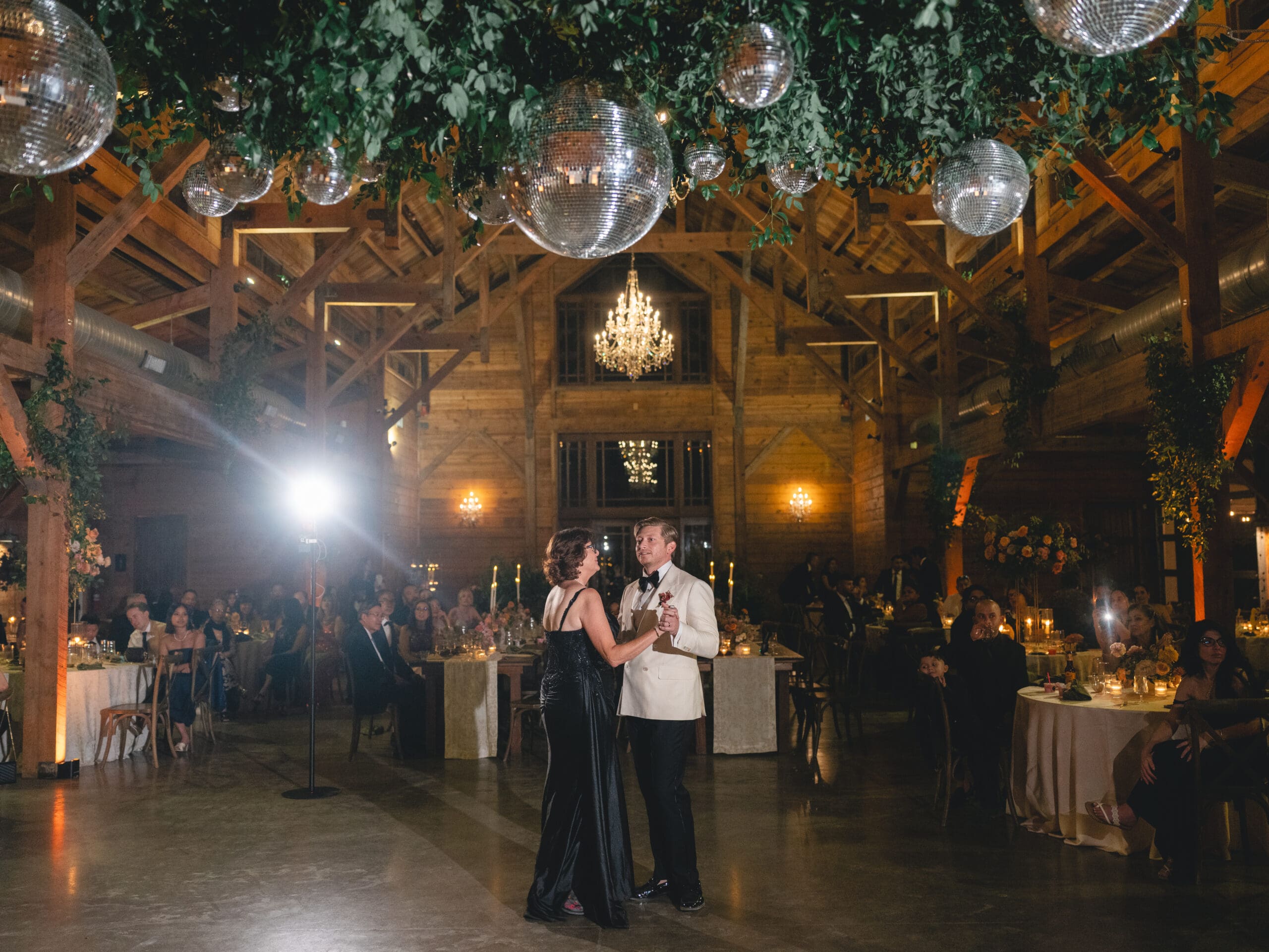First dance moment of Oanh and Jeremy in the barn at The Addison Grove surrounded by friends and family