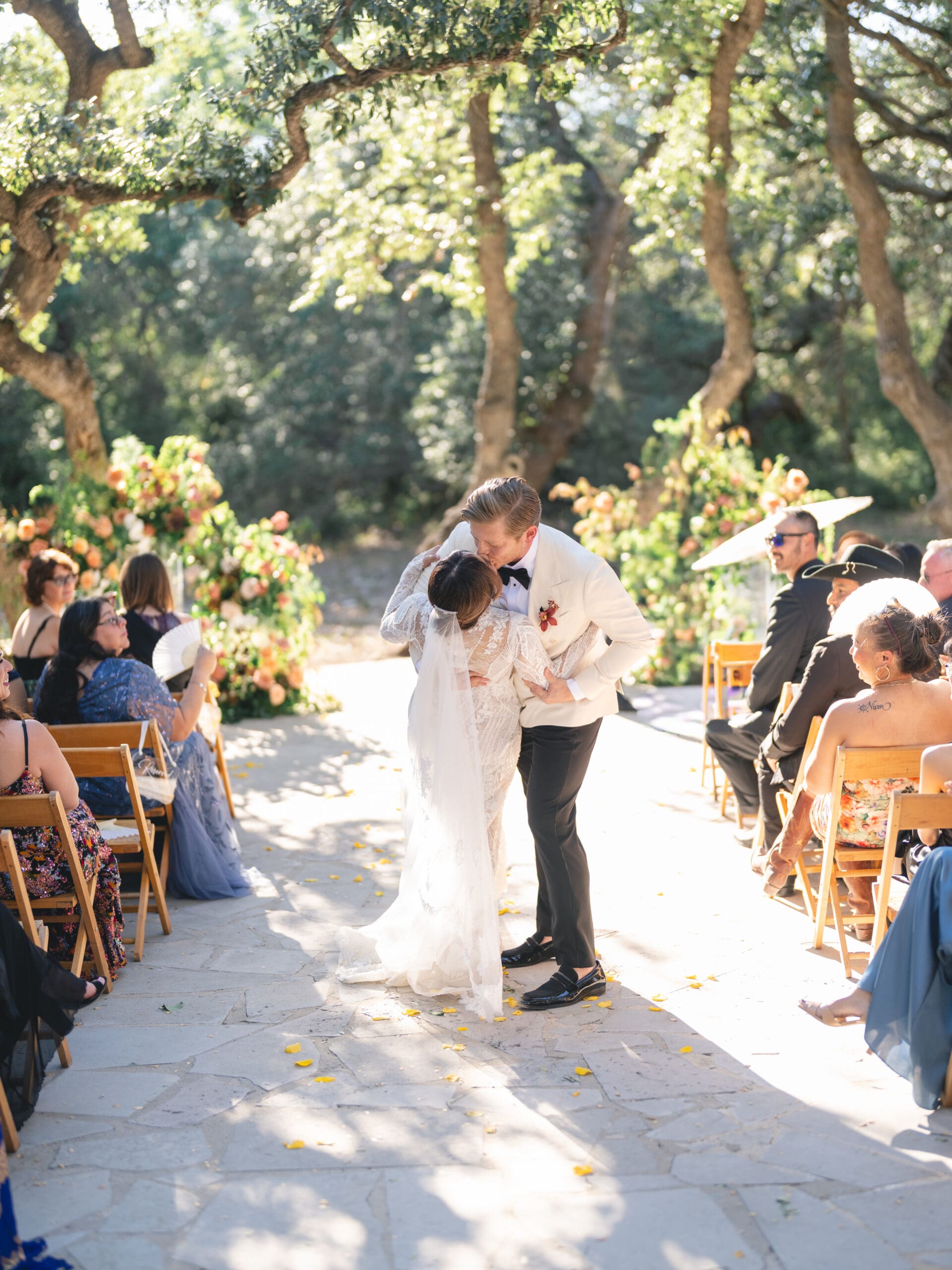 Outdoor ceremony at The Addison Grove with guests seated beneath twinkling lights and oak trees