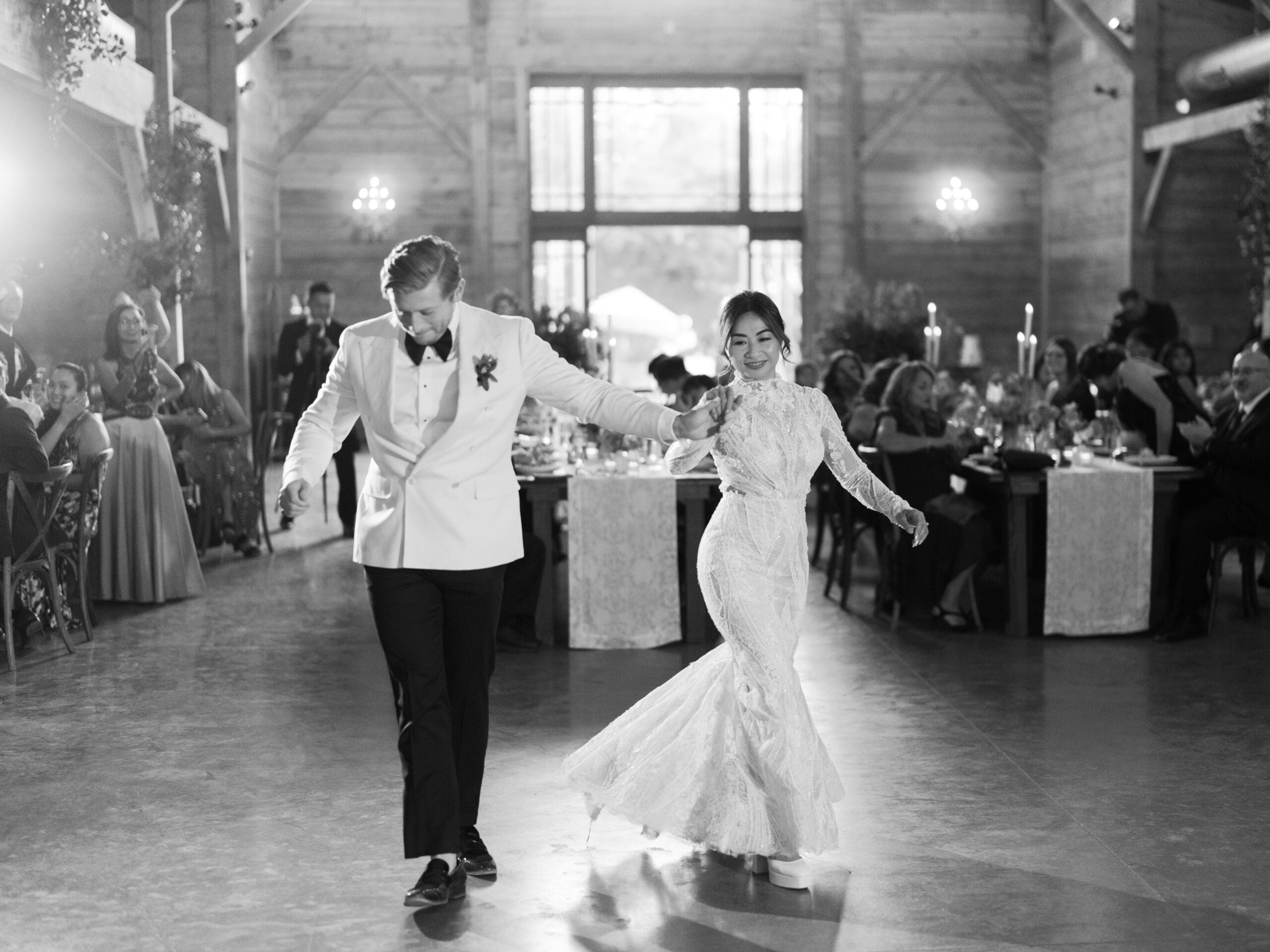 First dance moment of Oanh and Jeremy in the barn at The Addison Grove surrounded by friends and family