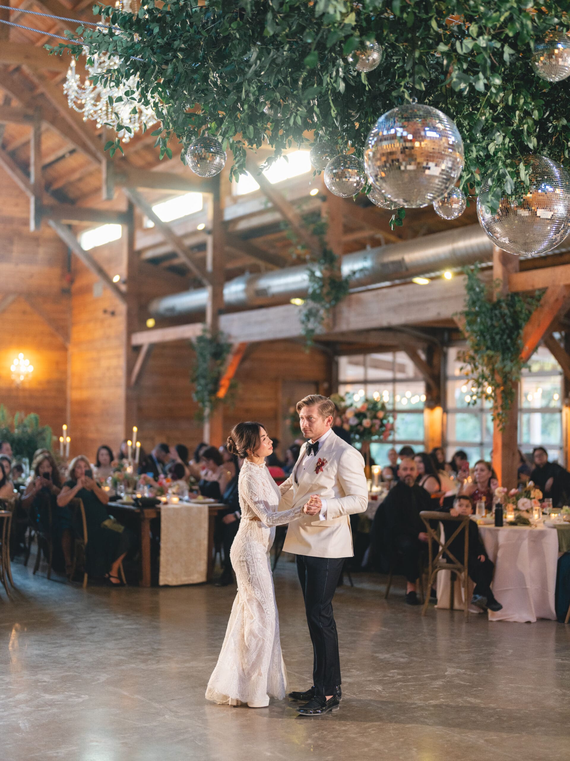 First dance moment of Oanh and Jeremy in the barn at The Addison Grove surrounded by friends and family