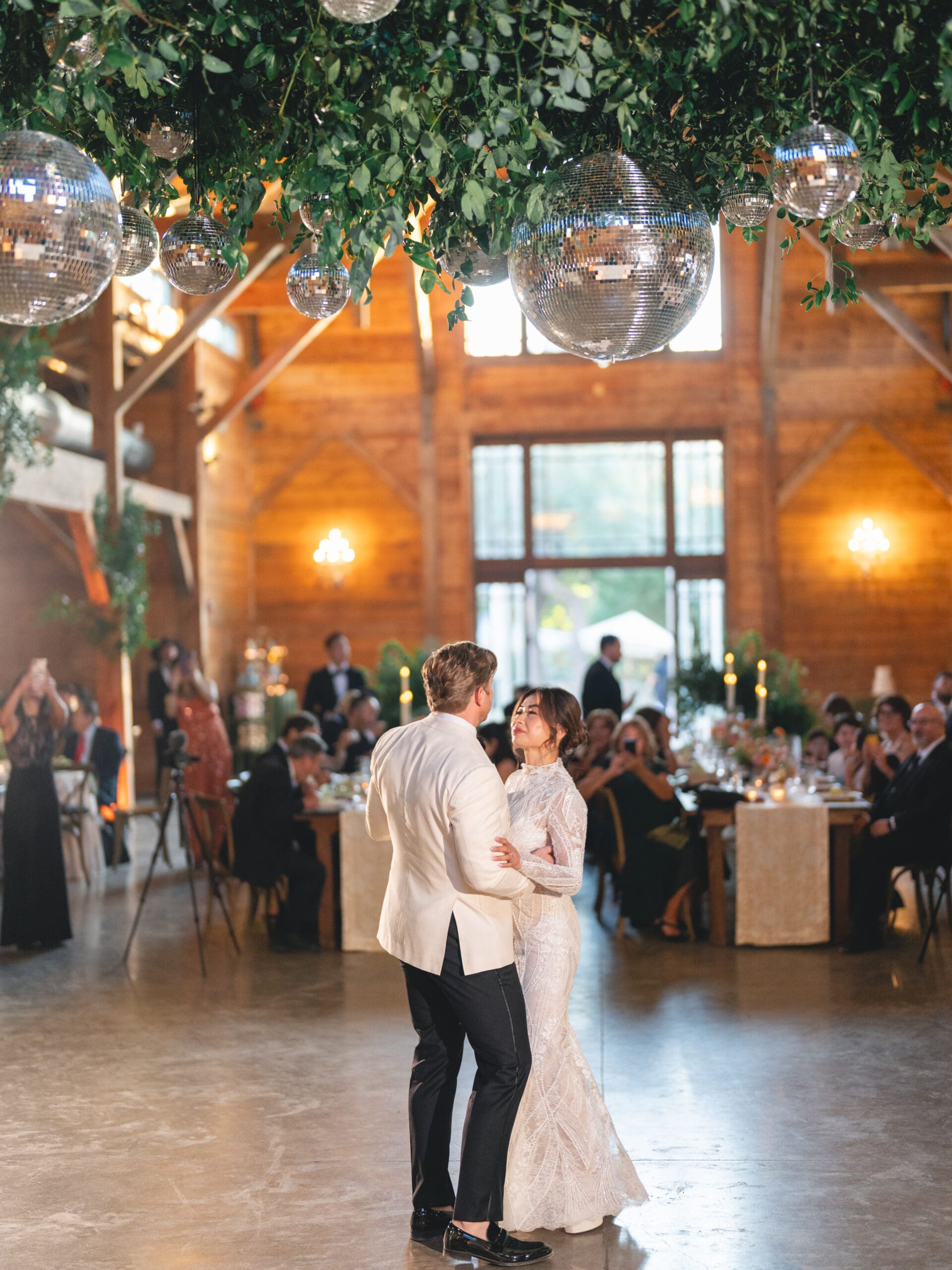 First dance moment of Oanh and Jeremy in the barn at The Addison Grove surrounded by friends and family