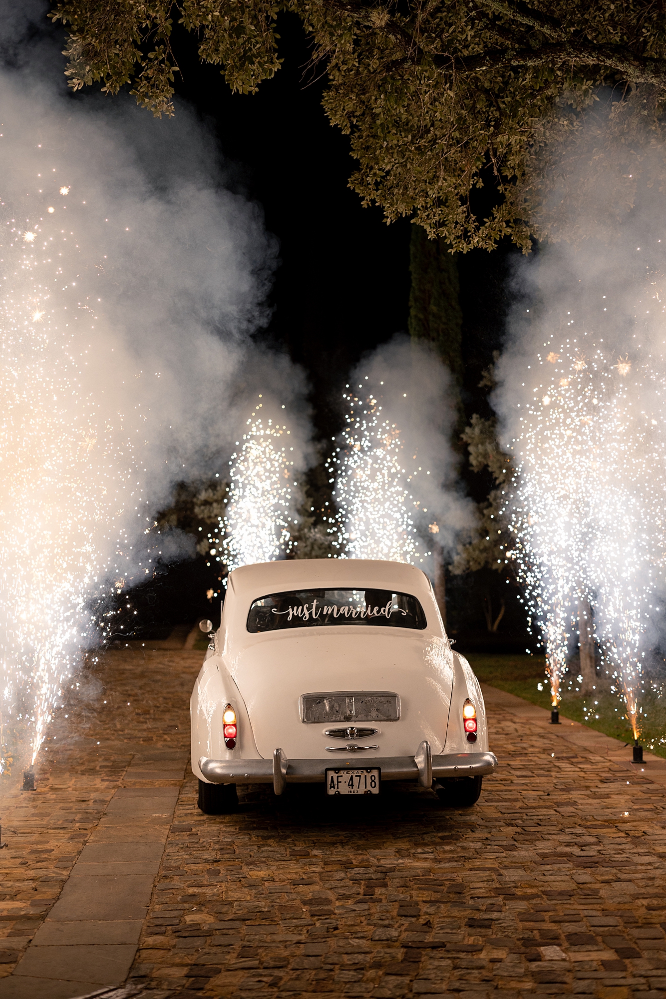 Nighttime exit of bride and groom amidst sparkler send-off in getaway car at Escondido Golf Club, Texas wedding inspiration
