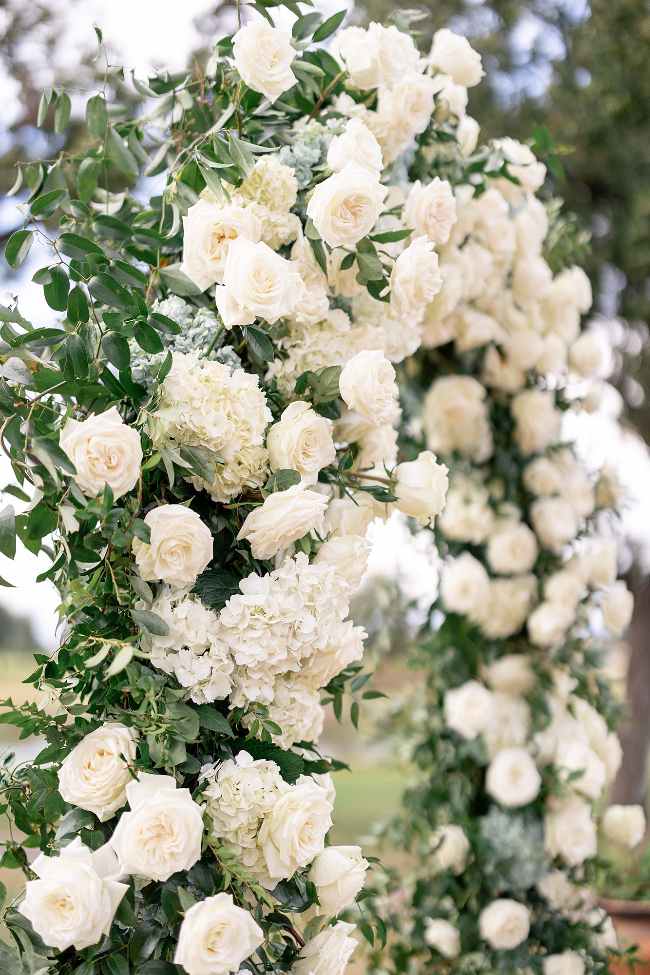 Outdoor ceremony moment at Escondido Golf Club with guests seated and floral arch backdrop