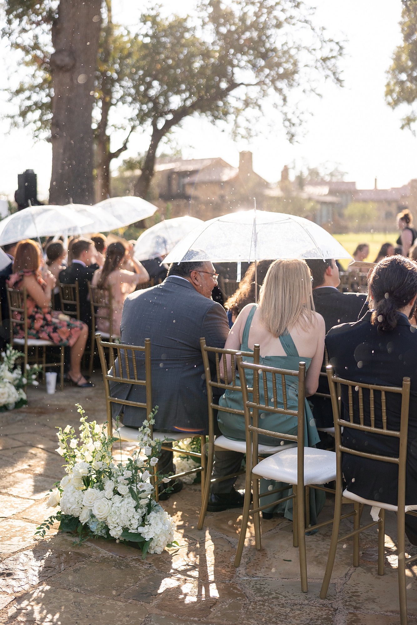 Outdoor ceremony moment at Escondido Golf Club with guests seated and floral arch backdrop