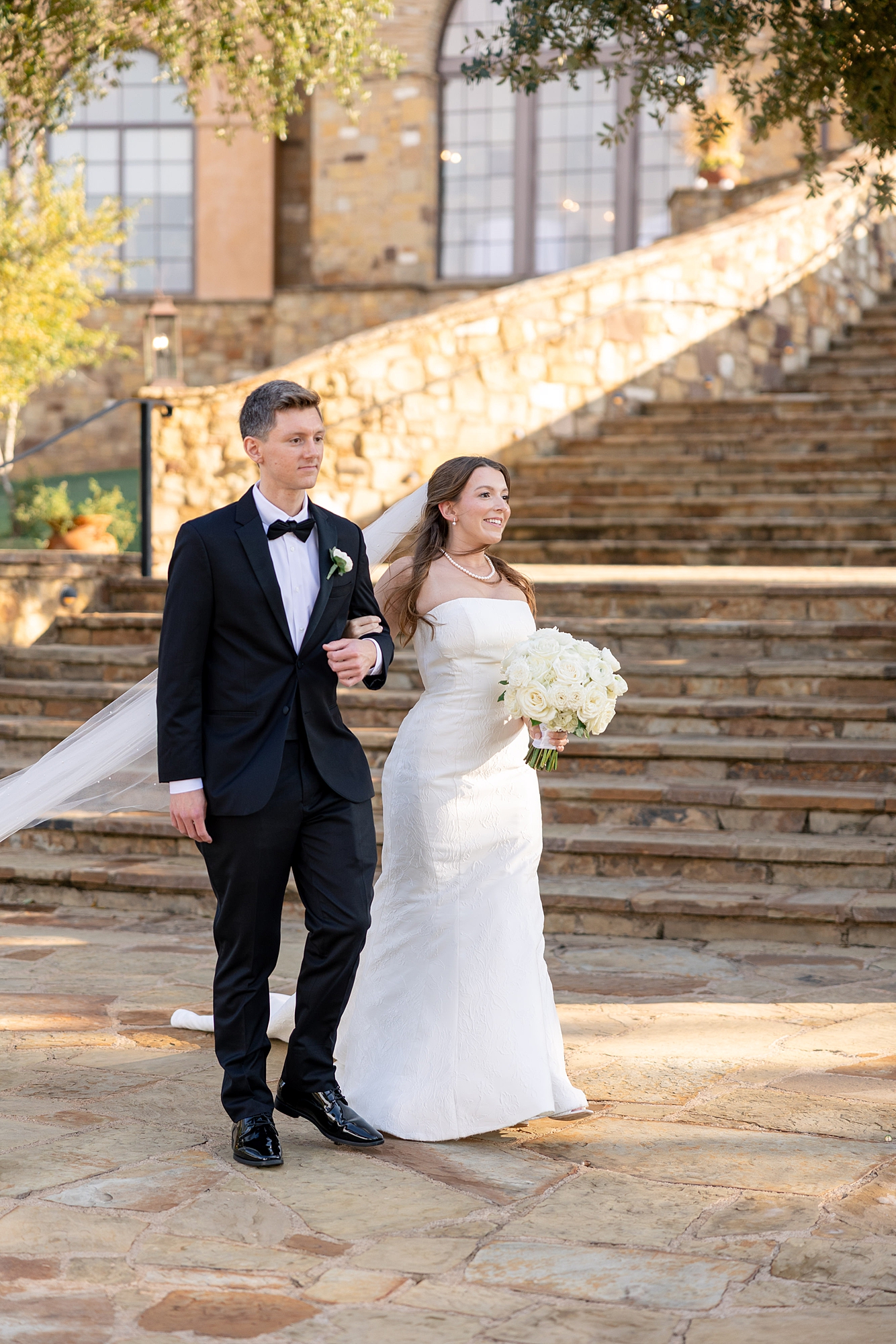 Outdoor ceremony moment at Escondido Golf Club with guests seated and floral arch backdrop