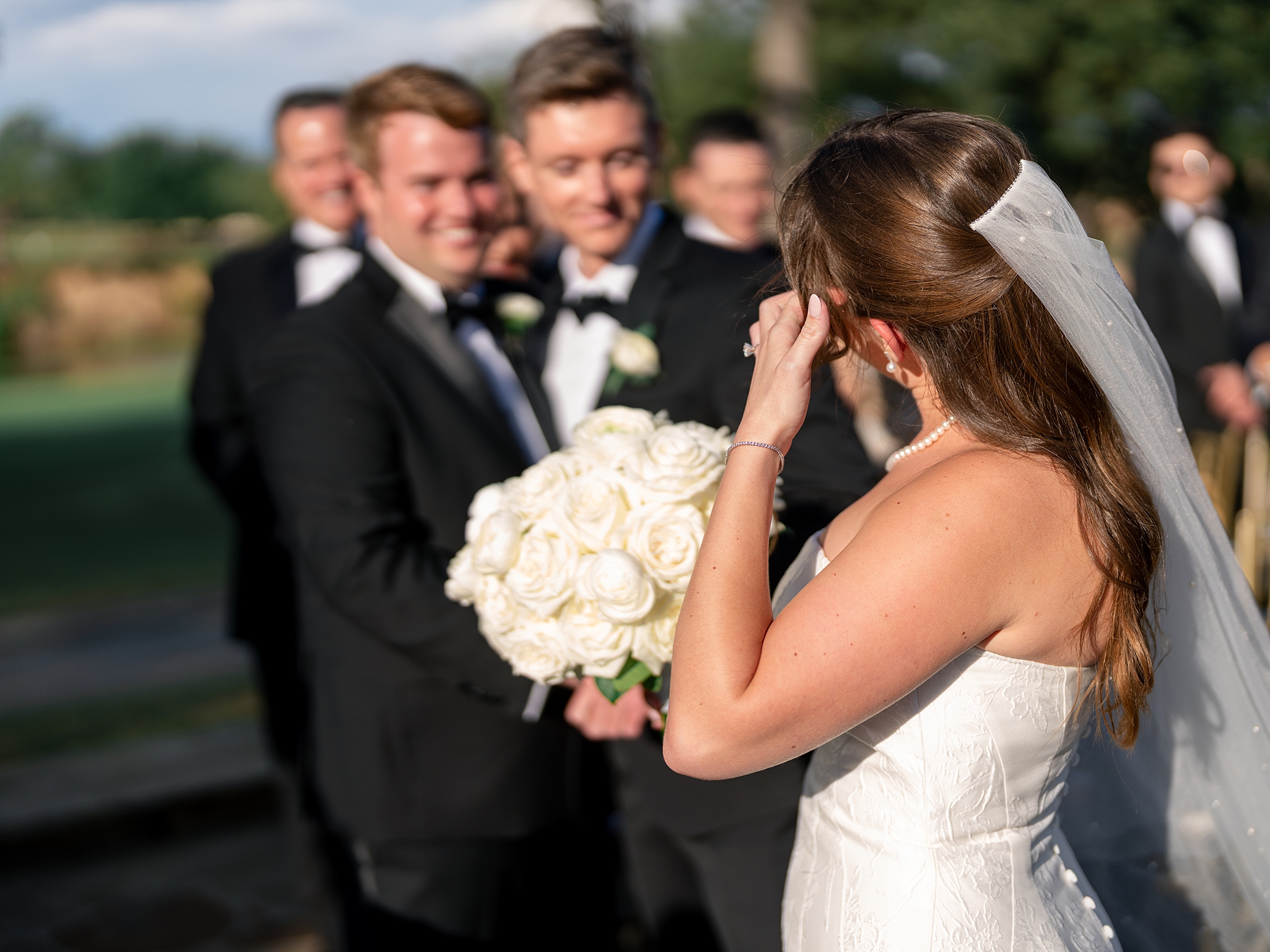 Outdoor ceremony moment at Escondido Golf Club with guests seated and floral arch backdrop
