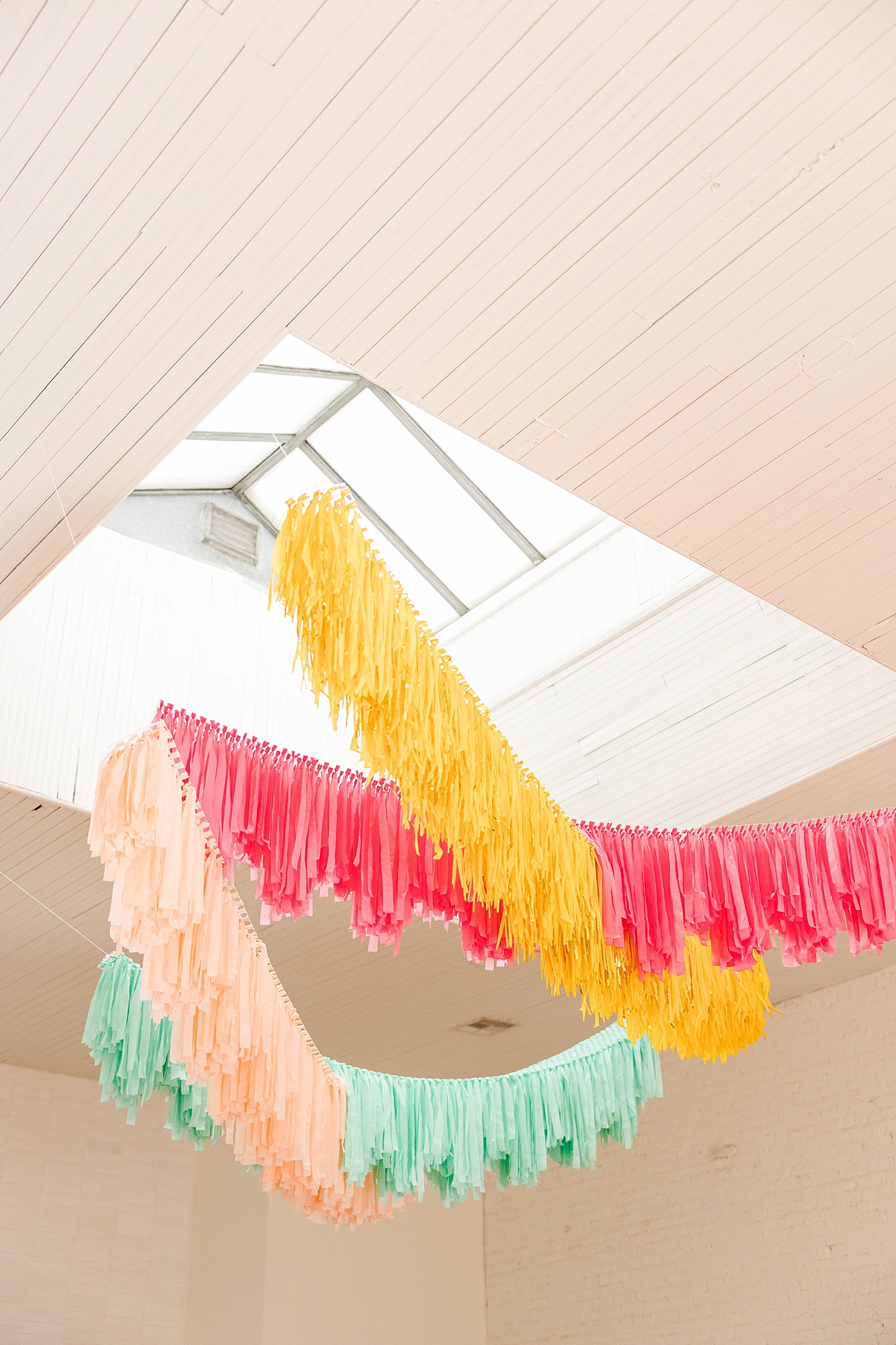 Western reception with retro-inspired decor in peach, mustard, teal and orange, guests dancing under fall light