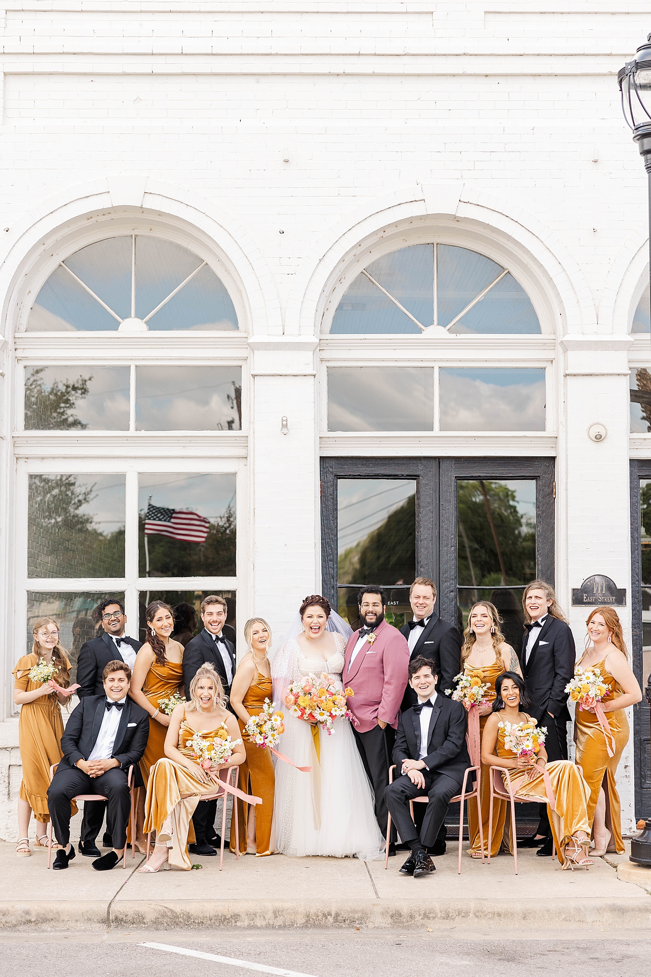 Joyful portrait of bride and groom mid-celebration at their fall wedding weekend in Texas, wedding party