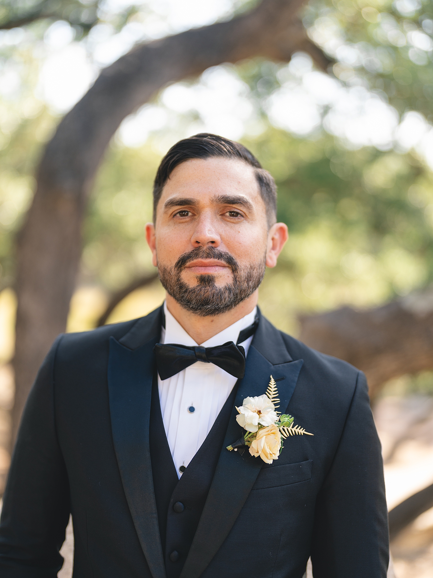 Groom adjusting his tie in preparation for ceremony at San Antonio wedding