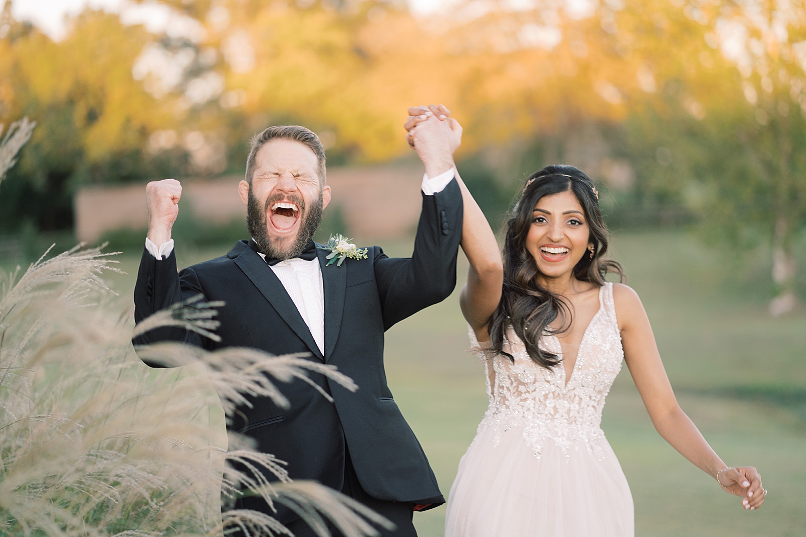 Newlywed bride and groom cheer while holding hands after being married, posing for wedding photos with Paige Vaughn Photography