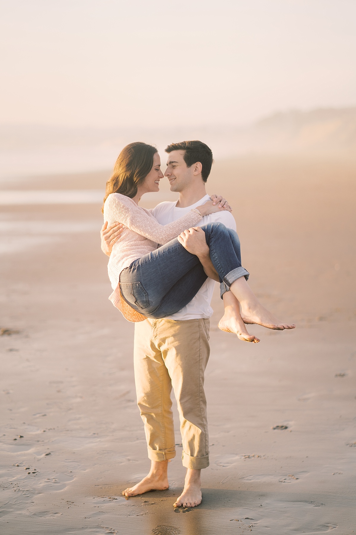 Cute couple standing by the ocean in California for engagement photos with Paige Vaughn Photography
