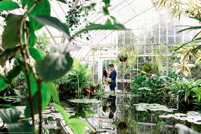 Couple stands for wedding photos in popular San Francisco wedding venue the Conservatory of Flowers