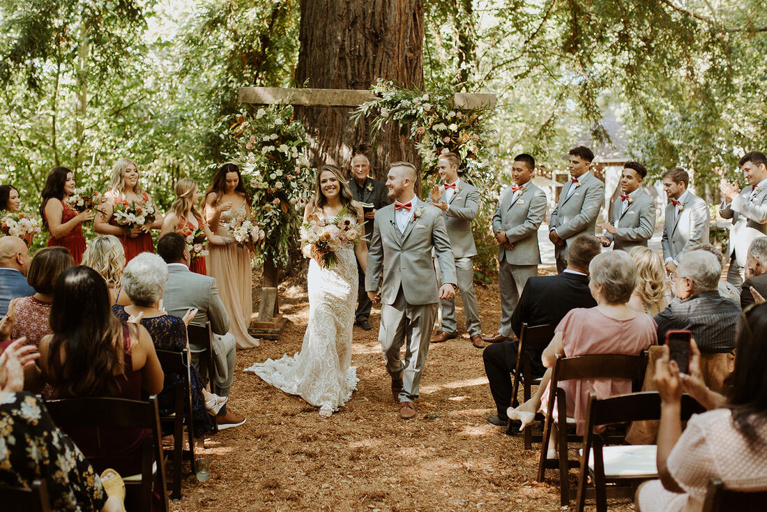 Newlywed bride and groom walk down the aisle together at a beautiful outdoor wedding ceremony at California Bay Area outdoor wedding venue, Sand Rock Farm