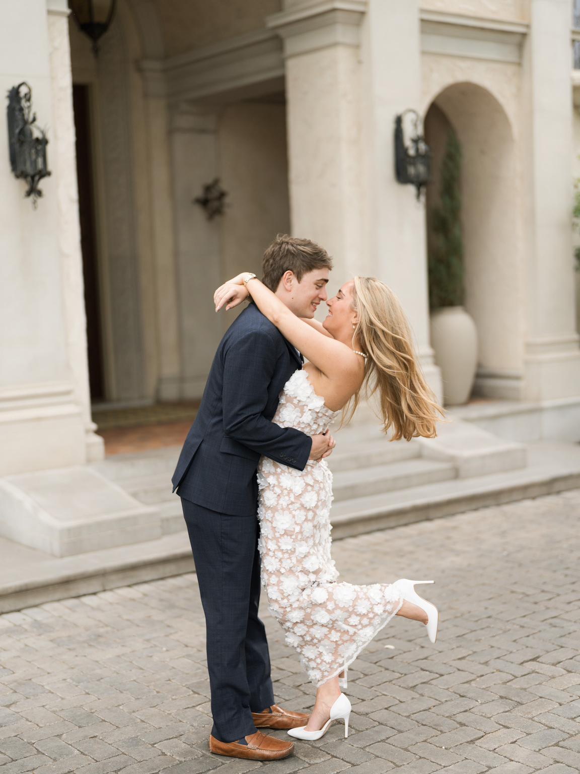Engaged couple walking through the elegant gardens of Commodore Perry Estate, captured on film with soft natural light and classic architecture in the background