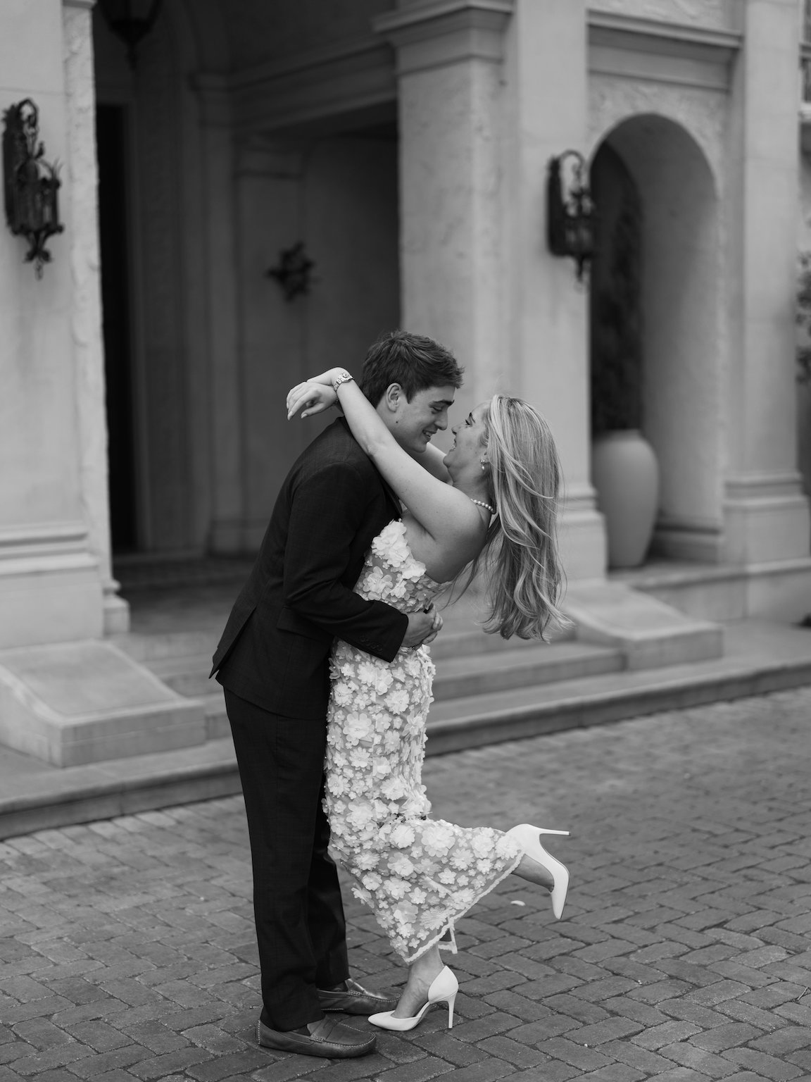 Engaged couple walking through the elegant gardens of Commodore Perry Estate, captured on film with soft natural light and classic architecture in the background