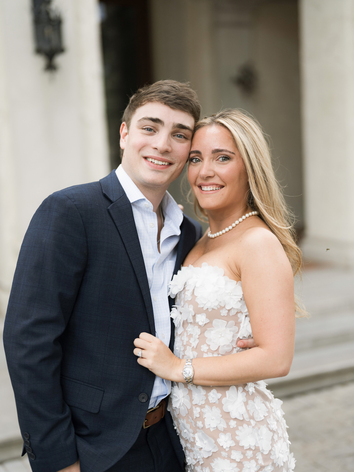 Engaged couple walking through the elegant gardens of Commodore Perry Estate, captured on film with soft natural light and classic architecture in the background