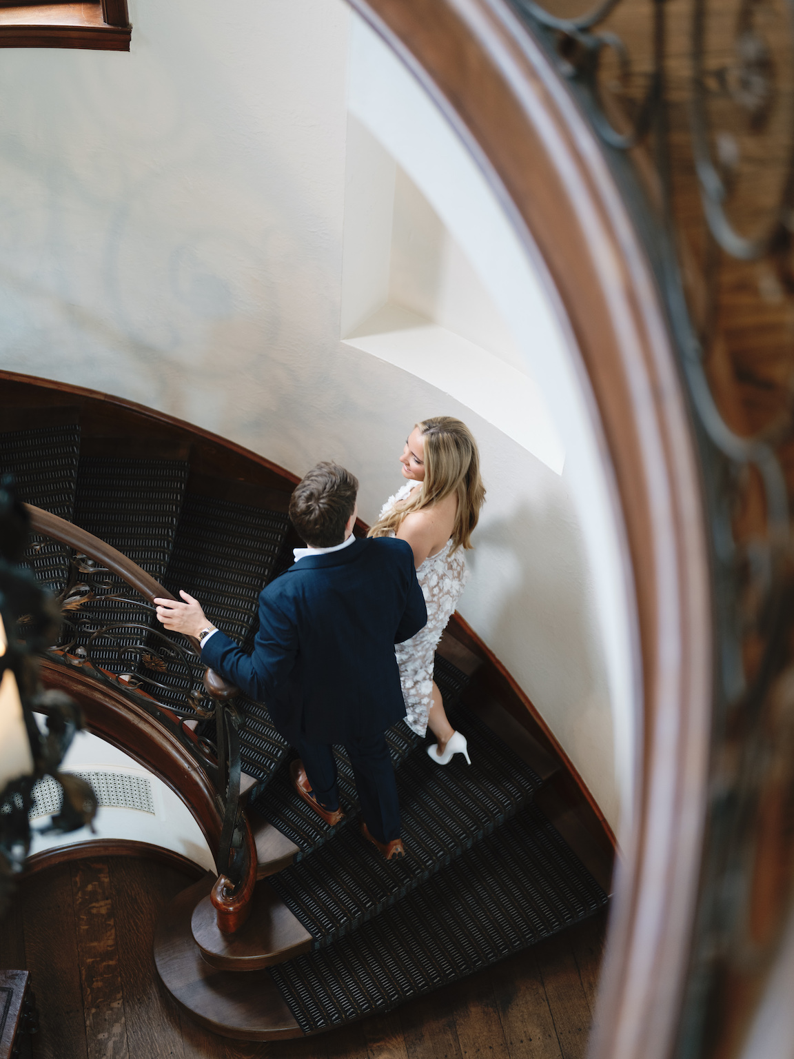 Engaged couple walking through the elegant gardens of Commodore Perry Estate, captured on film with soft natural light and classic architecture in the background