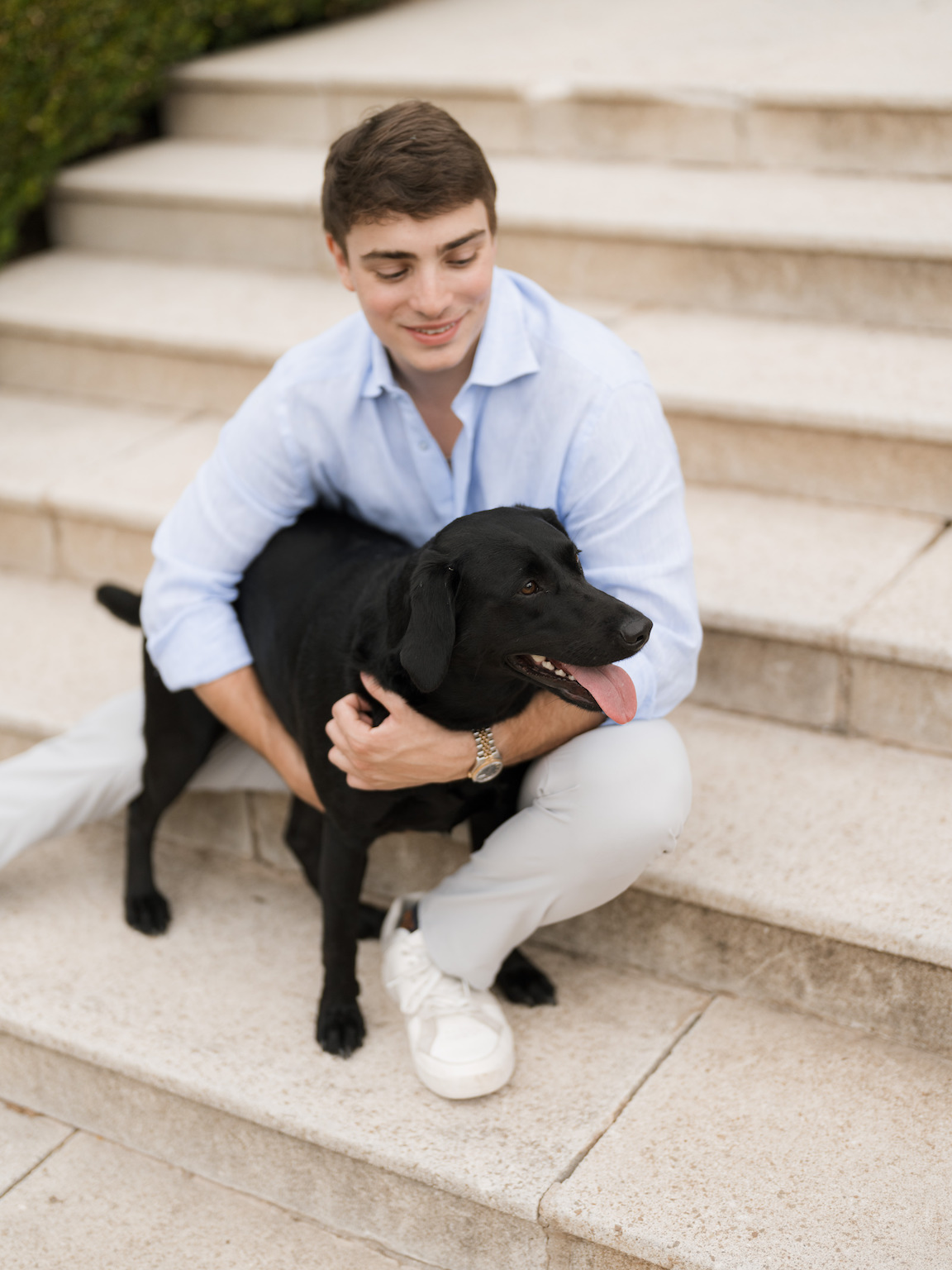 Engagement photo of couple cuddling with their dogs on the lawn of Commodore Perry Estate
