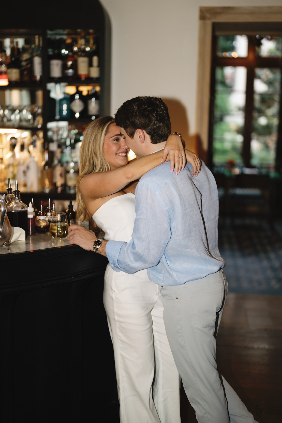 Elegant indoor portrait of engaged couple sitting at the vintage bar at Commodore Perry Estate in Austin