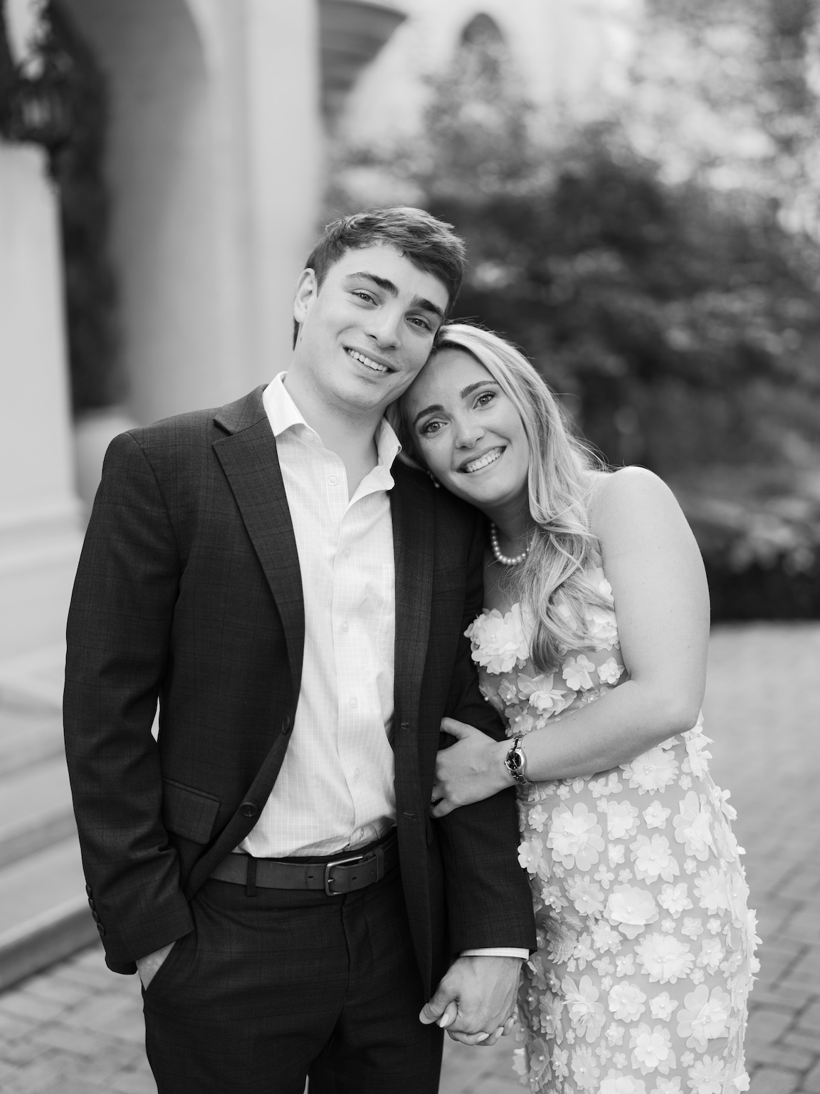 Engaged couple walking through the elegant gardens of Commodore Perry Estate, captured on film with soft natural light and classic architecture in the background