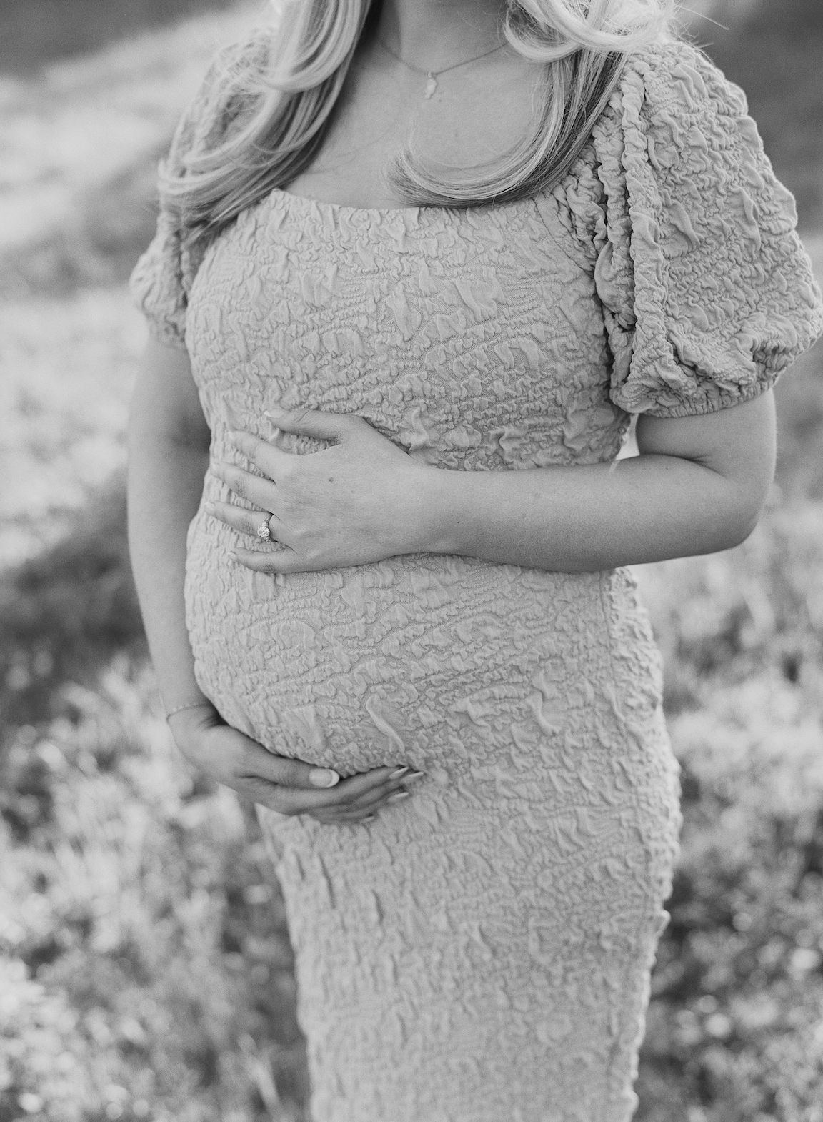 Expecting mother in a grassy field, photographed on film with glowing natural light
