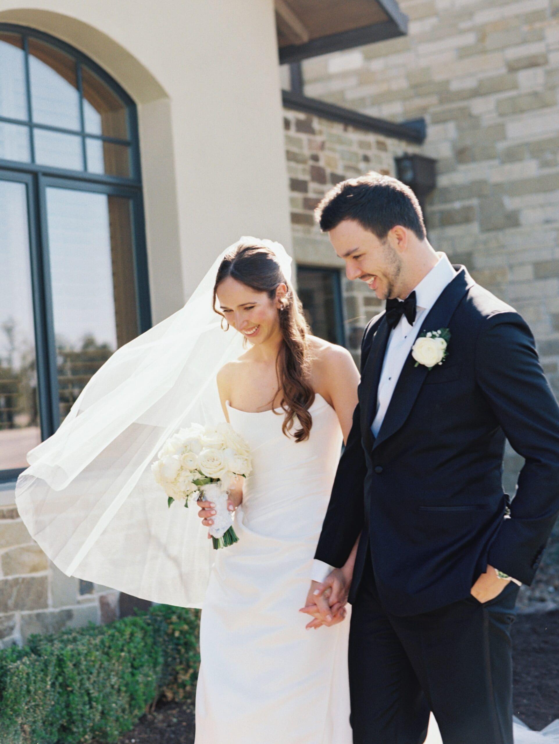 Bride and groom sharing sunset wedding portraits overlooking the Texas Hill Country at Canyonwood Ridge wedding venue.